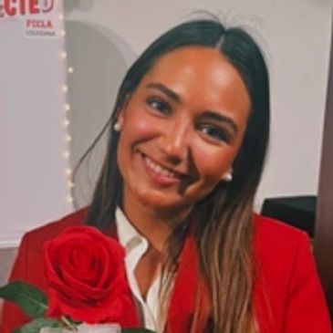 Woman smiling with a red rose.