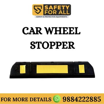 Black car wheel stopper with yellow reflective strips for safety.