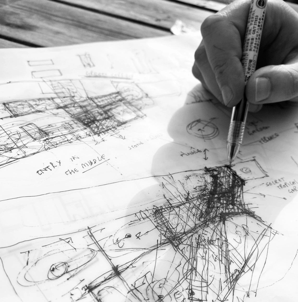 Hand sketching architectural designs on paper.