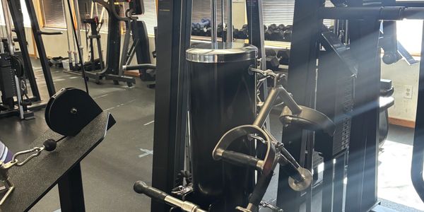 A gym machine with pulleys and handles for strength training exercises.