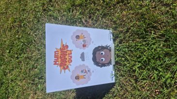 A colorful illustrated book titled 'Mummy Magic Out' on grass.