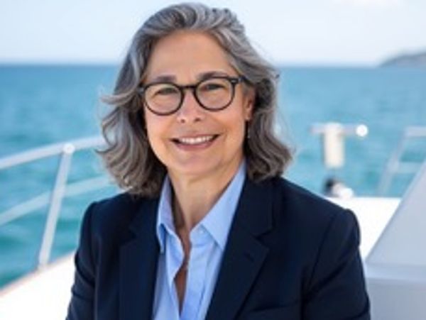 Smiling woman with gray hair and glasses on a boat.
