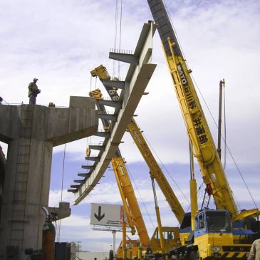 Grúa levantando una estructura de metal en construcción.
