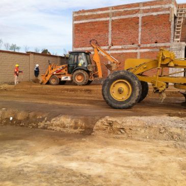 Maquinaria y trabajadores en obra de construcción.