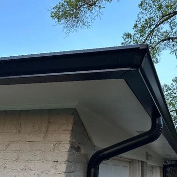 6" Black K-style seamless gutters and round downspouts.