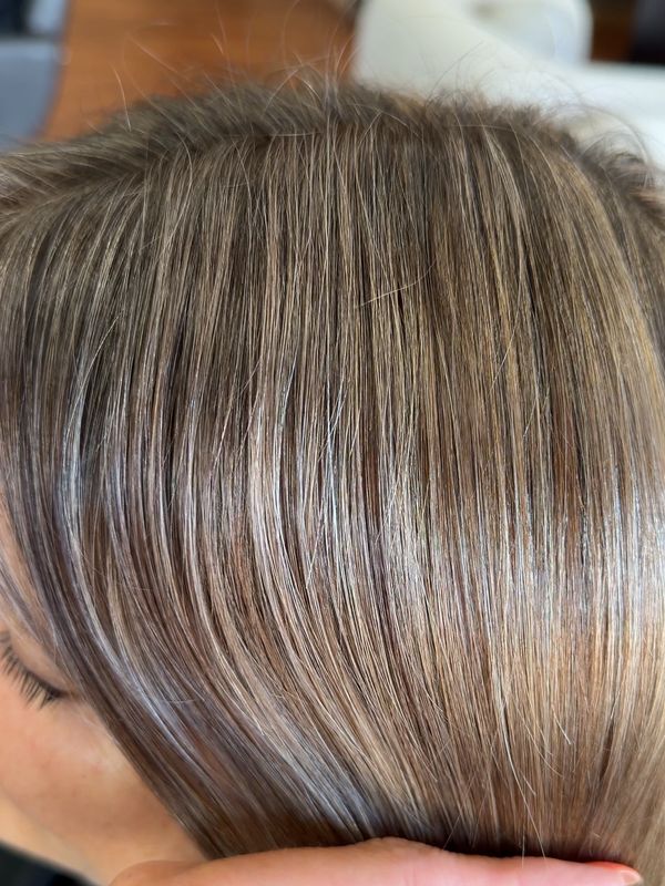 Close-up of smooth, shiny light brown hair with subtle highlights.