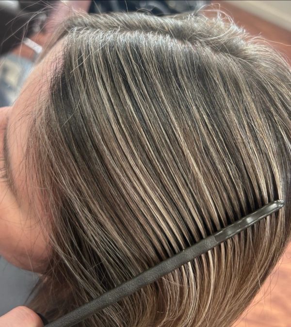 Close-up of hair with highlights being combed.