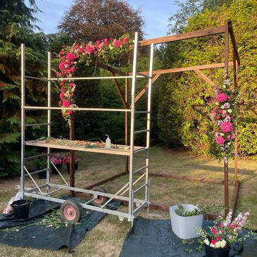 wooden wedding arch adorned in beautiful pink flowers