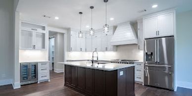 Modern kitchen with white cabinets and a dark wood island.