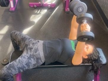 Person lifting dumbbells on bench.