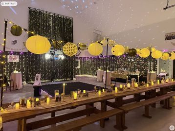Indoor party setup with yellow lanterns and string lights.