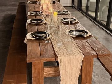 Elegant wooden dining table set with candles and glassware for a formal dinner.
