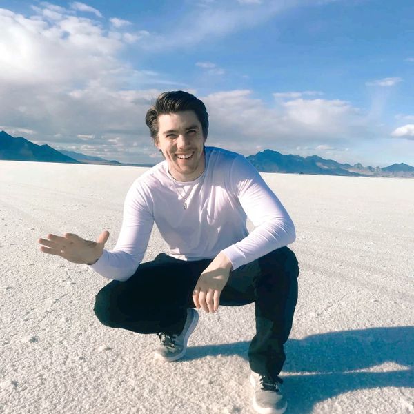 Dan Kelley squatting and smiling with a background of the Bonneville Salt Flats