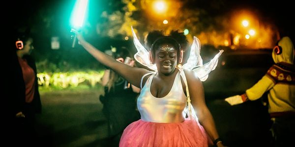 Silent disco dancer with fairy wings and glowing lights