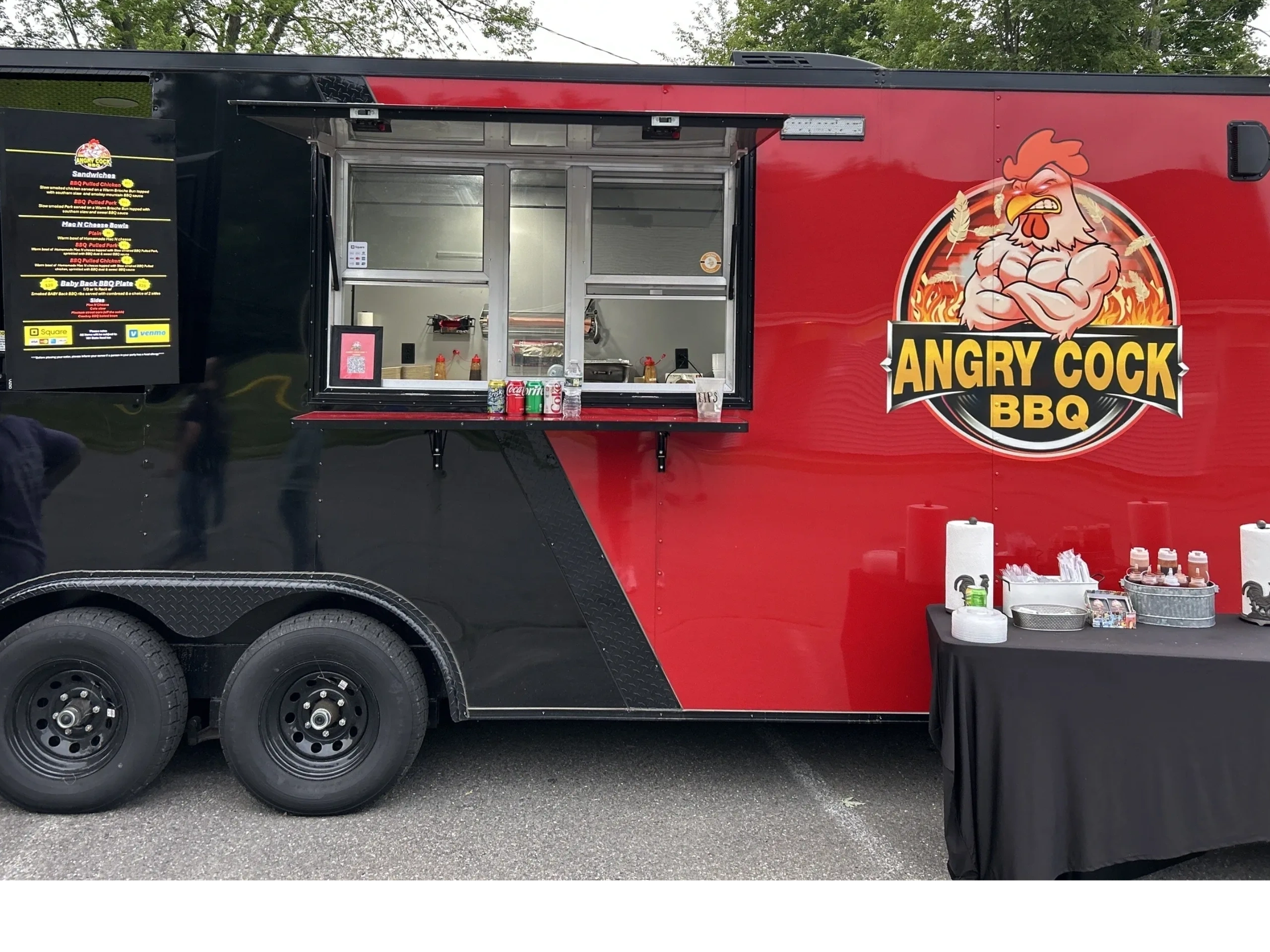 A BBQ food truck named Angry Cock BBQ with a muscular rooster logo.