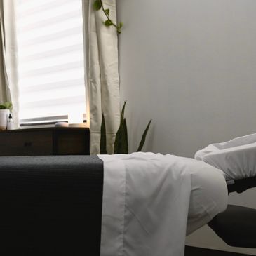Cozy and minimalist bedroom corner with natural light and plants.