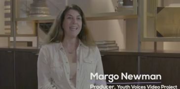 Margo Newman, producer of the Youth Voices Video Project, smiling and seated indoors.