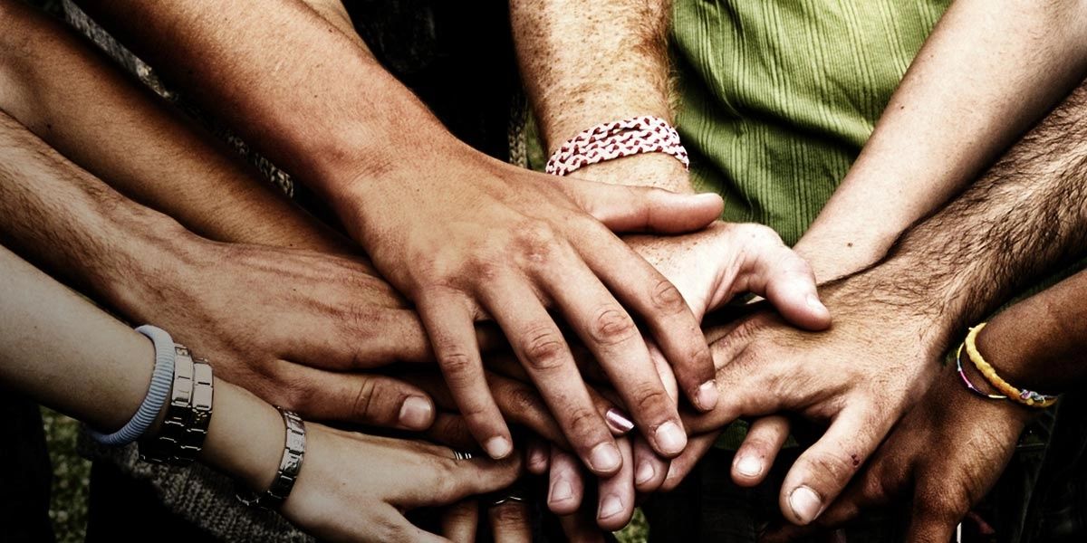 Several hands stacked together, symbolizing unity.