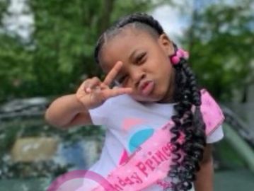 Little girl posing with peace sign and braided hair.