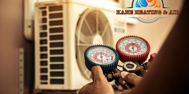 Technician checking HVAC system with pressure gauges.