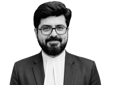 Man with beard and glasses in formal attire.
