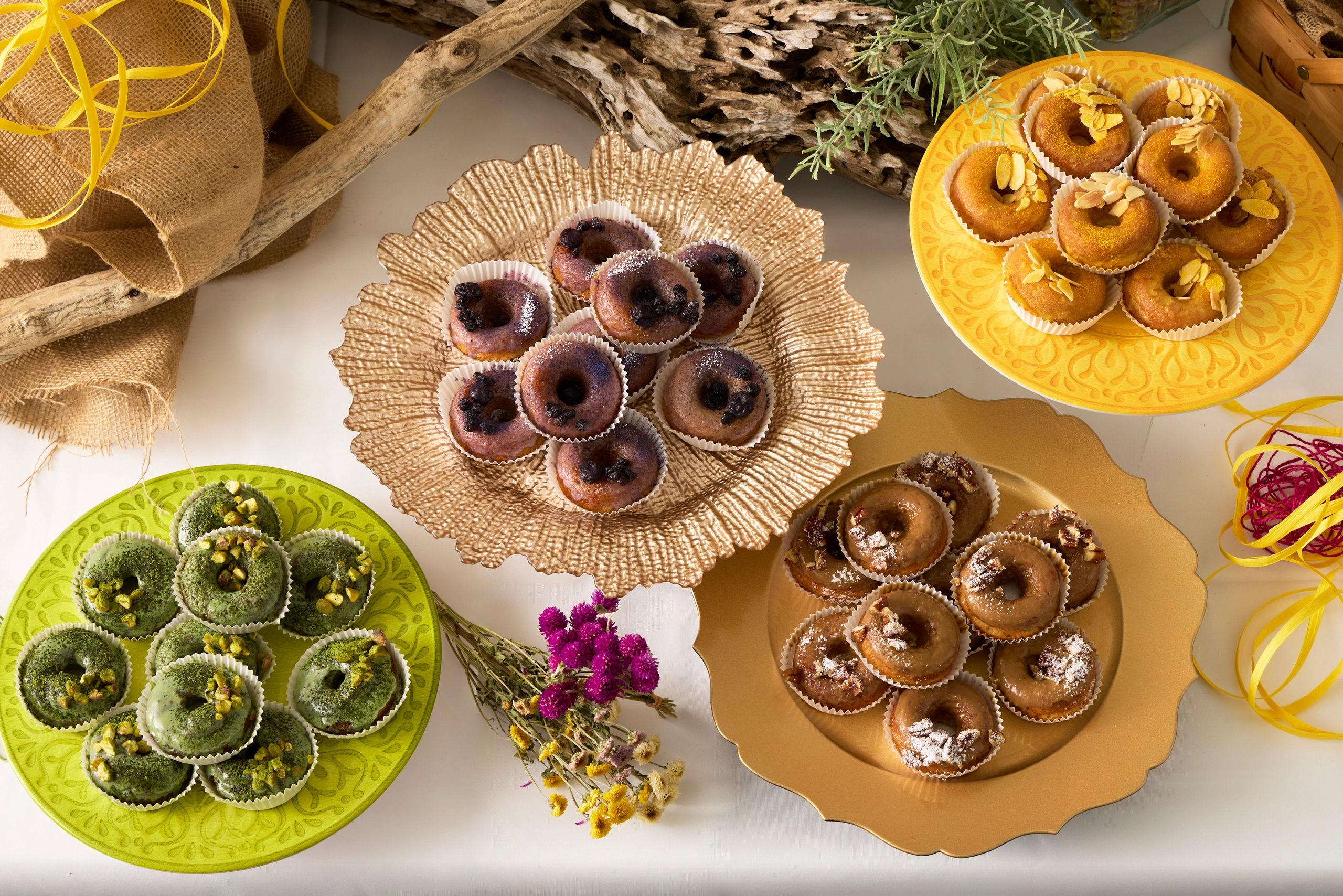 Colorful mini donuts displayed on decorative plates with natural decor.
