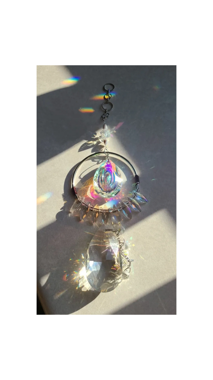 Crystal suncatcher reflecting vibrant rainbow light on a surface.