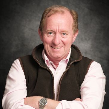 Smiling man posing with arms crossed.