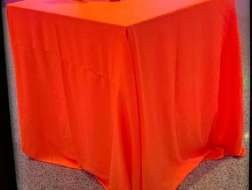 A picture of the orange liner on the table with candle and vase
