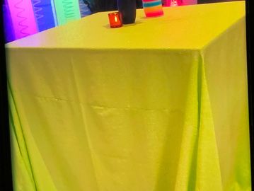 A picture of a yellow liner on the table with candle and a vase