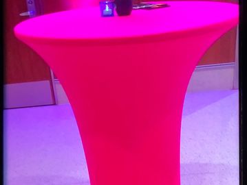 A picture of tall bar table with candle and a vase