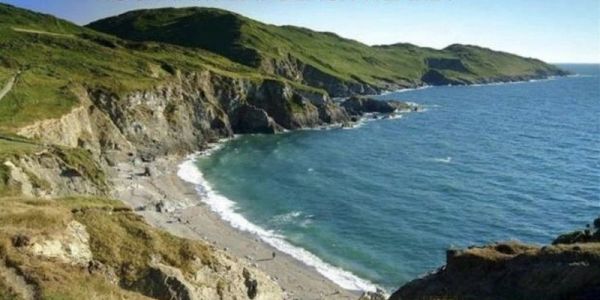 Scenic coastline with green hills and blue sea.