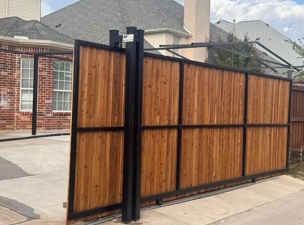  
Custom sliding cedar and steel driveway gate installation by Art Construction in Dallas–Fort Worth