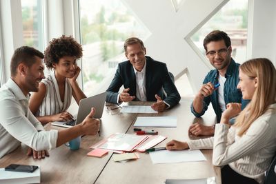 Diverse team engaged in a positive business meeting around a table.