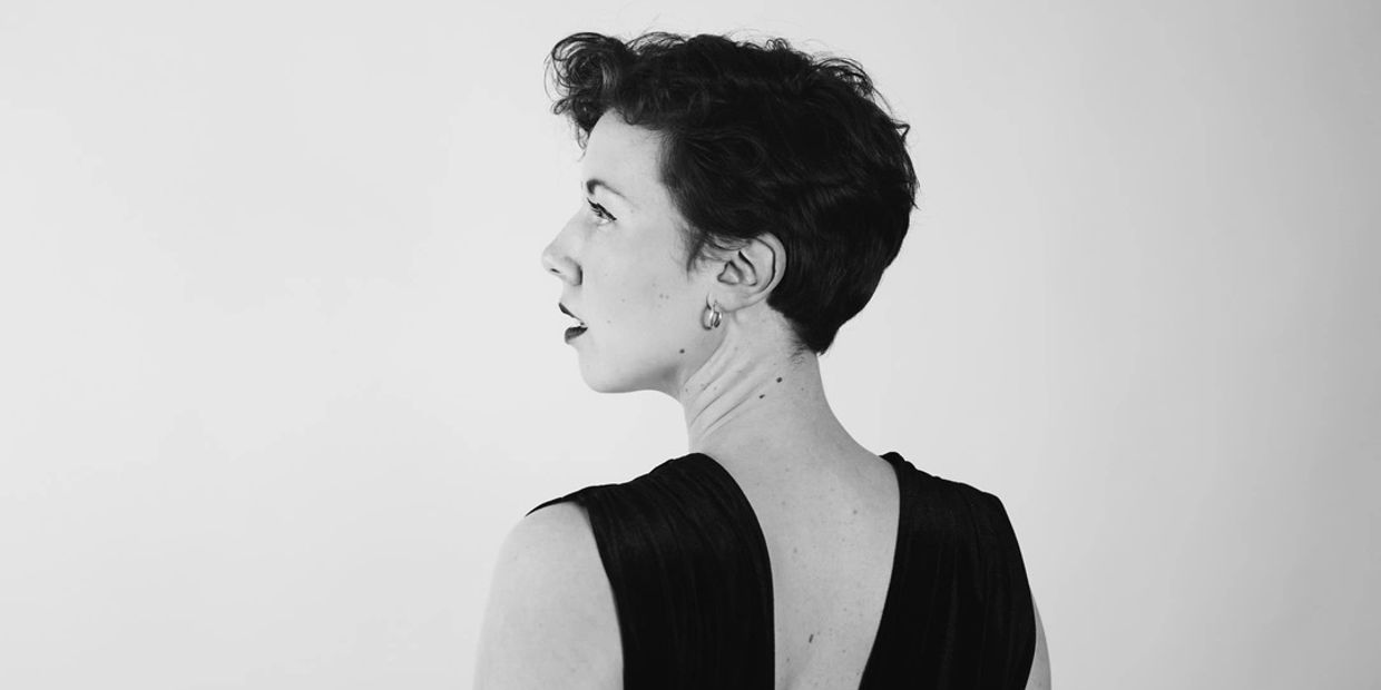 Black and white portrait of a woman looking sideways with short hair.