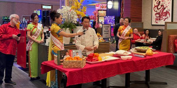 Martin Yan demonstrates his cooking skills at a table