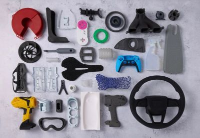 Array of various 3D printed parts and tools neatly arranged on a surface.