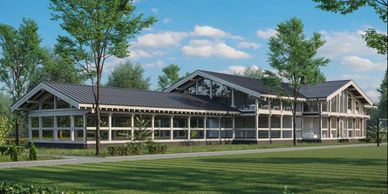 Modern, spacious house with large windows and metal roof in a green setting.