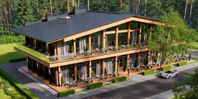 Modern two-story building with large windows surrounded by greenery and parking.