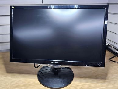 Black ViewSonic computer monitor on wooden desk.