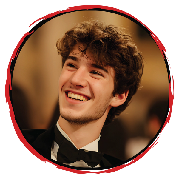 Young man smiling warmly in a tuxedo with a red circular frame.