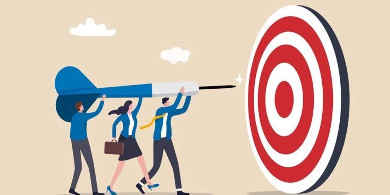 Teamwork aiming a giant dart at a target.