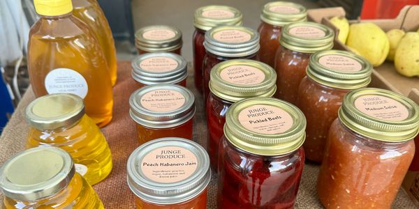 A variety of honey and canned goods that are available for sale at the farm stand