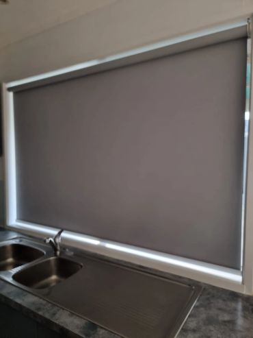 Closed gray window blind above kitchen sink.
