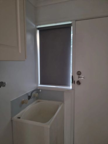 Laundry area with sink and window blind.