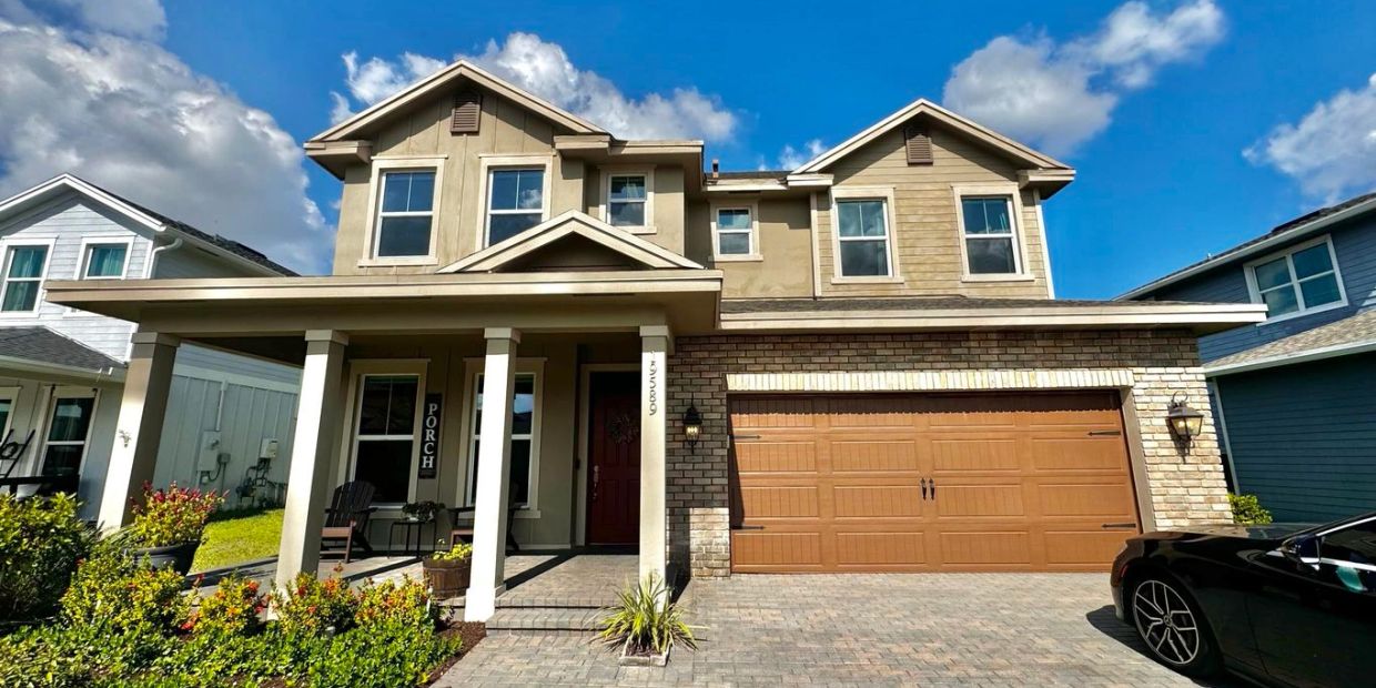 Modern two-story house with a large garage and porch.