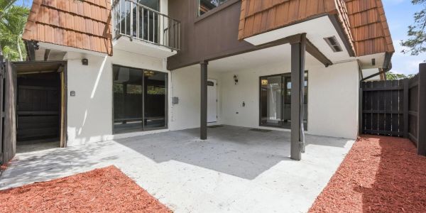 Empty backyard patio with mulch borders.
