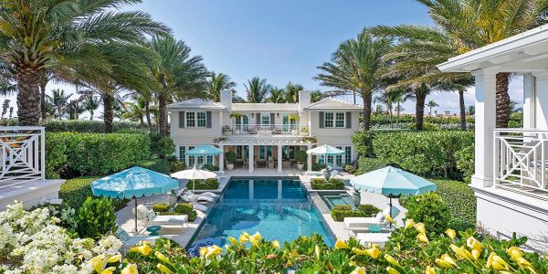 Luxury house with pool and blue umbrellas.