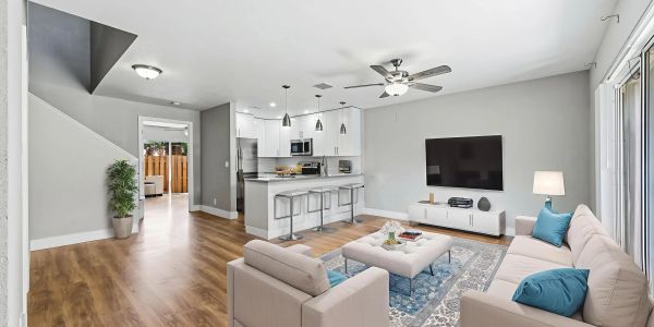 Modern open living room with kitchen and seating area.