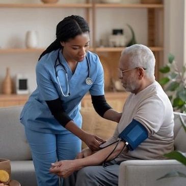 Nurse measuring elderly man's blood pressure at home.